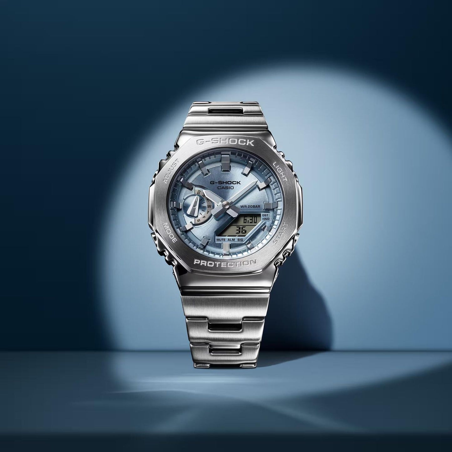 Elegant watch design featuring CASIO MOD. GM-2110D-2AER with metallic details and blue accents, showcased in spotlight.