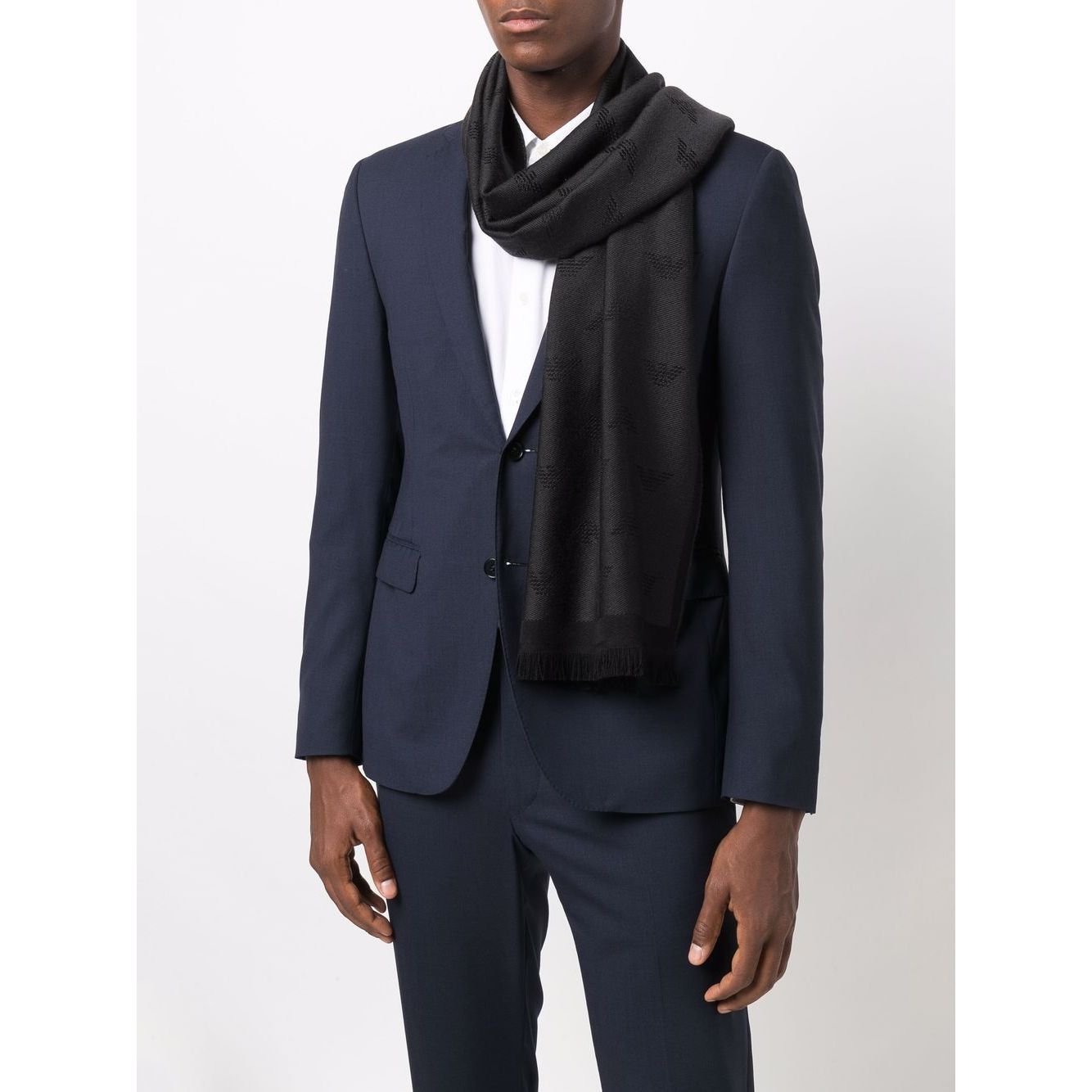 Man wearing Emporio Armani Allover logo wool scarf in black/anthracite grey with embroidered logo and frayed edge.