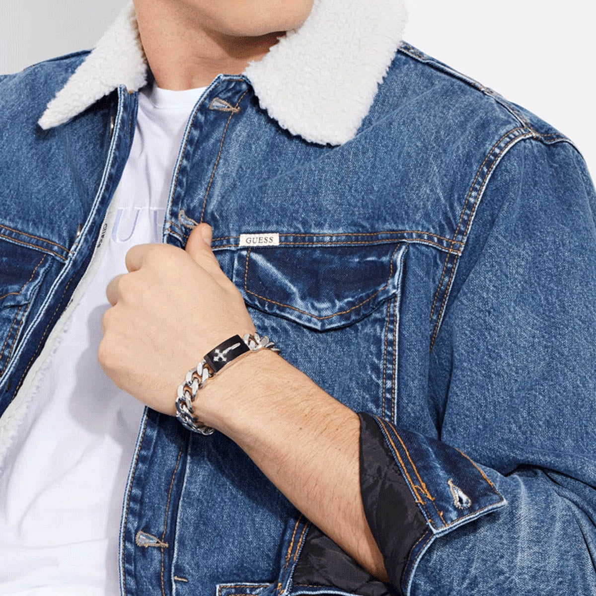 Model wearing denim jacket and GUESS JEWELS JEWELRY Mod. JUMB04022JWSTBKS bracelet.