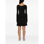 Model wearing JACQUEMUS Dresses Black ribbed knit dress with wide neck, long sleeves, and flared skirt, view from the back.