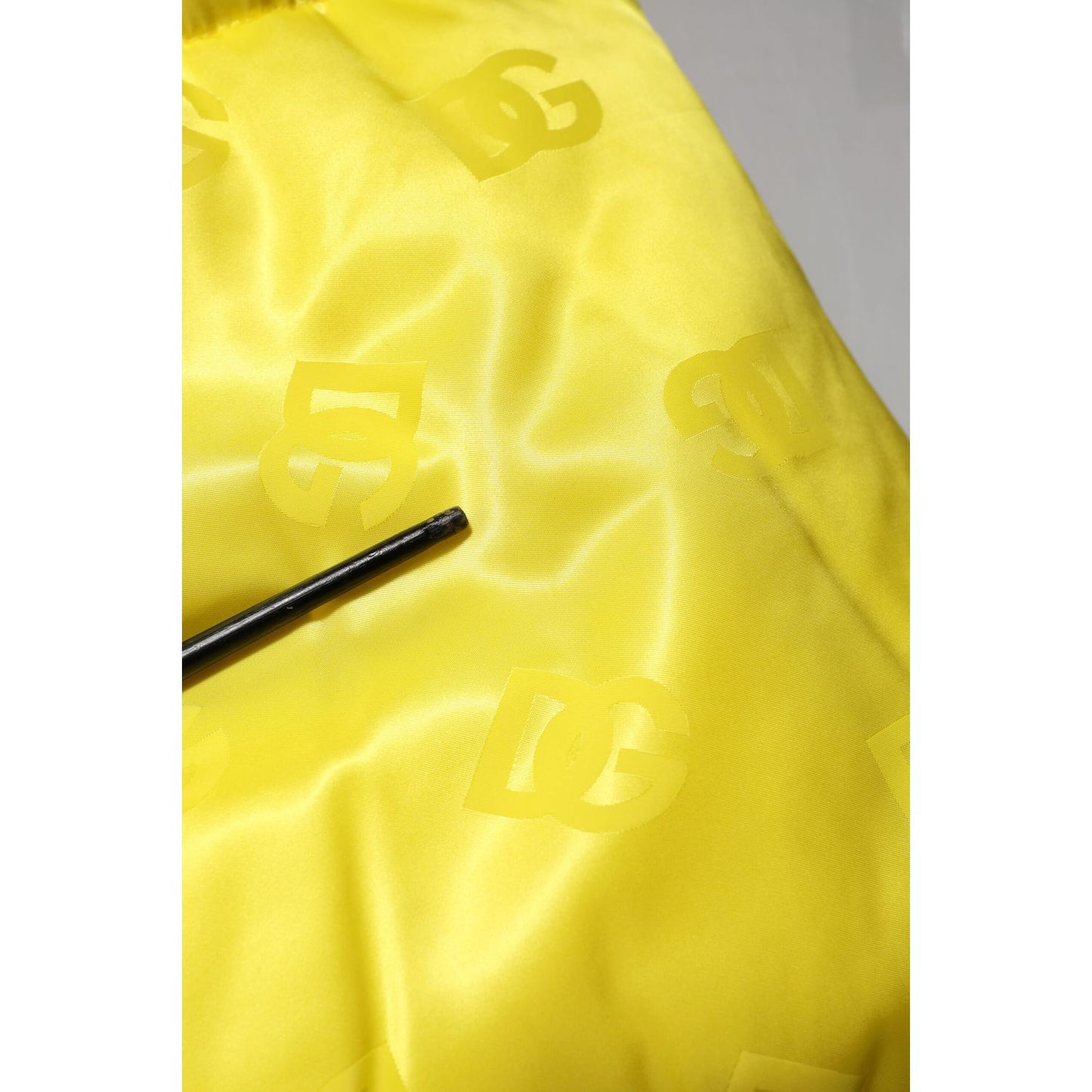 Close-up of Dolce & Gabbana Yellow Nylon Logo Puffer Bomber Men Jacket in vibrant yellow with DG logo detailing.