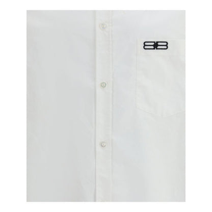 Balenciaga White Cotton Dress Shirt with embroidered logo, front button closure, and asymmetrical hem for a modern, oversized fit.