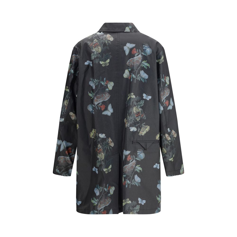 Undercover Black Cotton Coat with butterfly print, waxed finish, front flap pockets, and cotton lining, perfect for AW25 season.