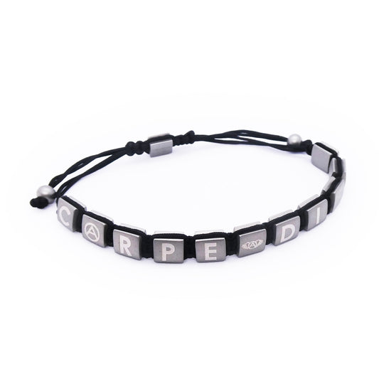 Black and silver bracelet with letter blocks spelling 'Carpe Diem' on a string. Stylish accessory for everyday wear.