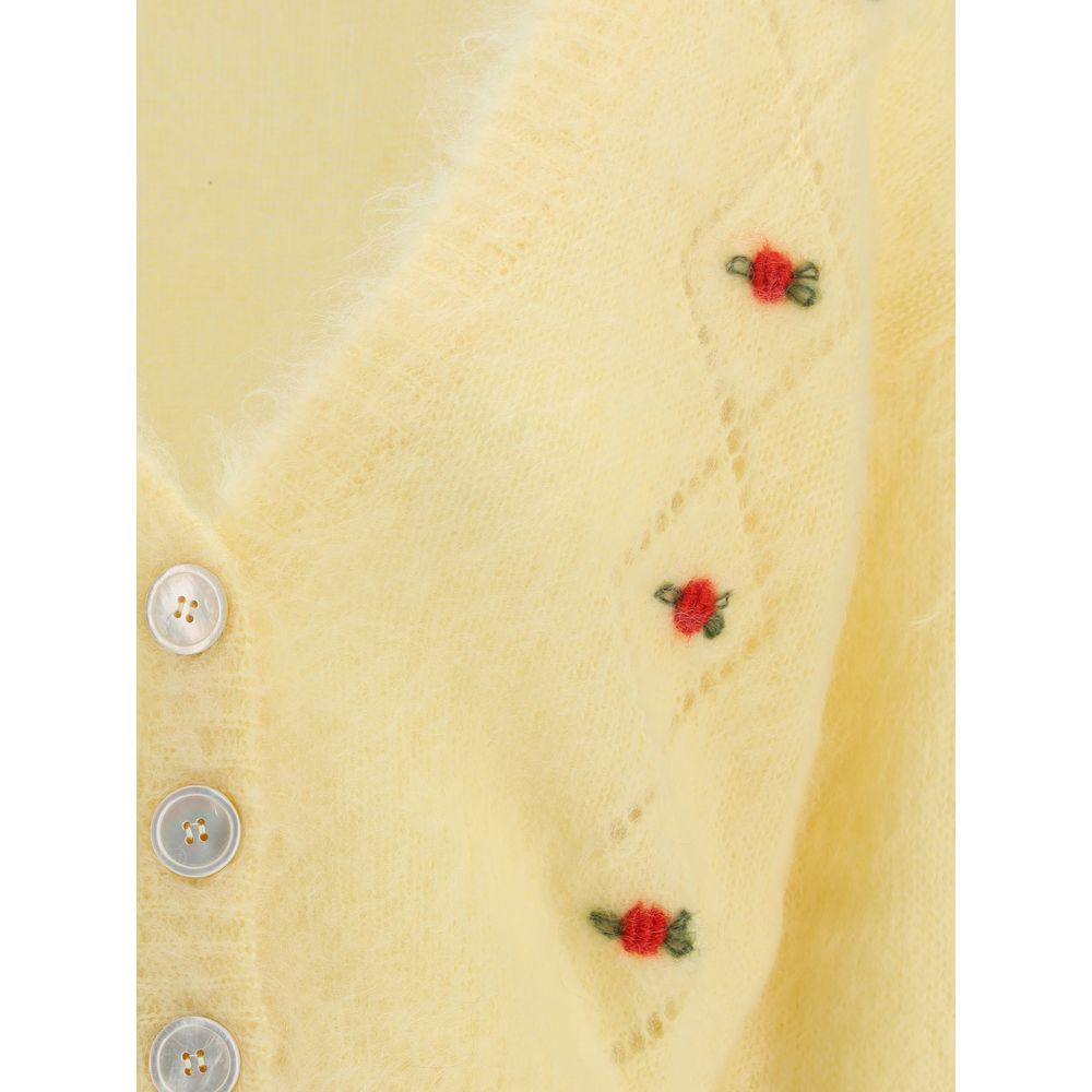 Close-up of Alessandra Rich Yellow Mohair Cardigan with floral embroidery and button closure, showing delicate perforated details.
