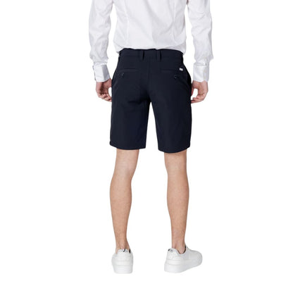 Rear view of Armani Exchange Blue Polyamide Bermuda Shorts on model wearing white shirt and sneakers.