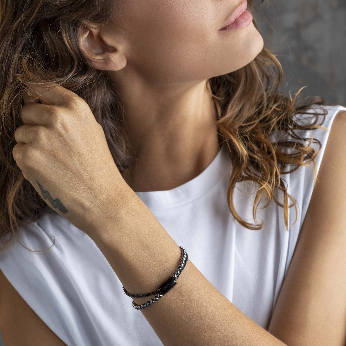 Lady wearing BREIL JEWELS Mod. TJ2938 bracelet with official packaging visible, showcasing elegant jewelry design.
