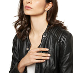 Woman wearing BREIL JEWELS Mod. TJ3157 silver earrings with leather jacket - elegant and stylish accessory.