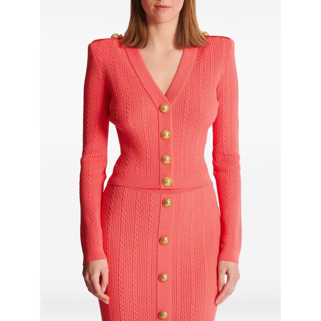 Coral pink Balmain long-sleeved twisted knit cardigan with gold logo-embossed buttons and plunging V-neck.