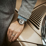 Man wearing CASIO EDIFICE Mod. STANDARD CHRONOGRAPH - CHAMPAGNE watch, hand resting on car, stylish design.