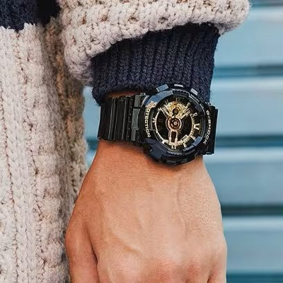 CASIO G-SHOCK Mod. GS-BASIC - BLACK ADN GOLD SERIES wristwatch with 20 ATM water resistance on wrist, black and gold design