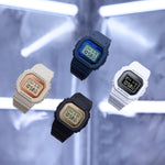 CASIO G-SHOCK Mod. THE ORIGIN Small wristwatches in various colors with resin straps and mineral dials, displayed against a neon backdrop.