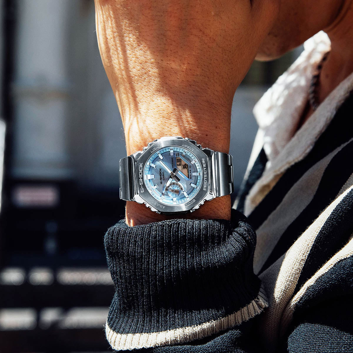 Man wearing CASIO MOD. GM-2110D-2AER watch on wrist, showcasing stylish design and functionality.
