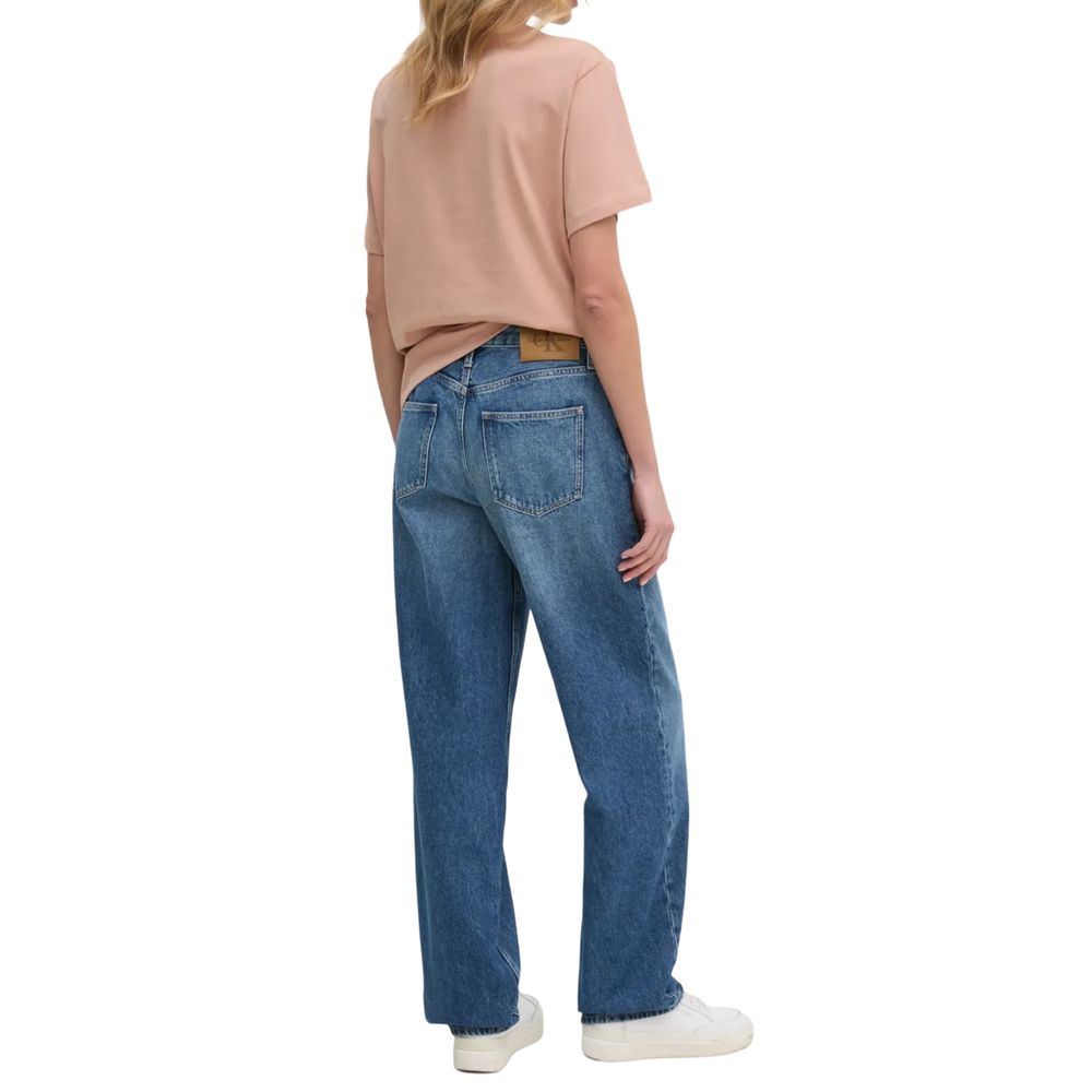 Rear view of woman wearing Calvin Klein Jeans Blue Cotton Mom Jeans with casual top and sneakers.