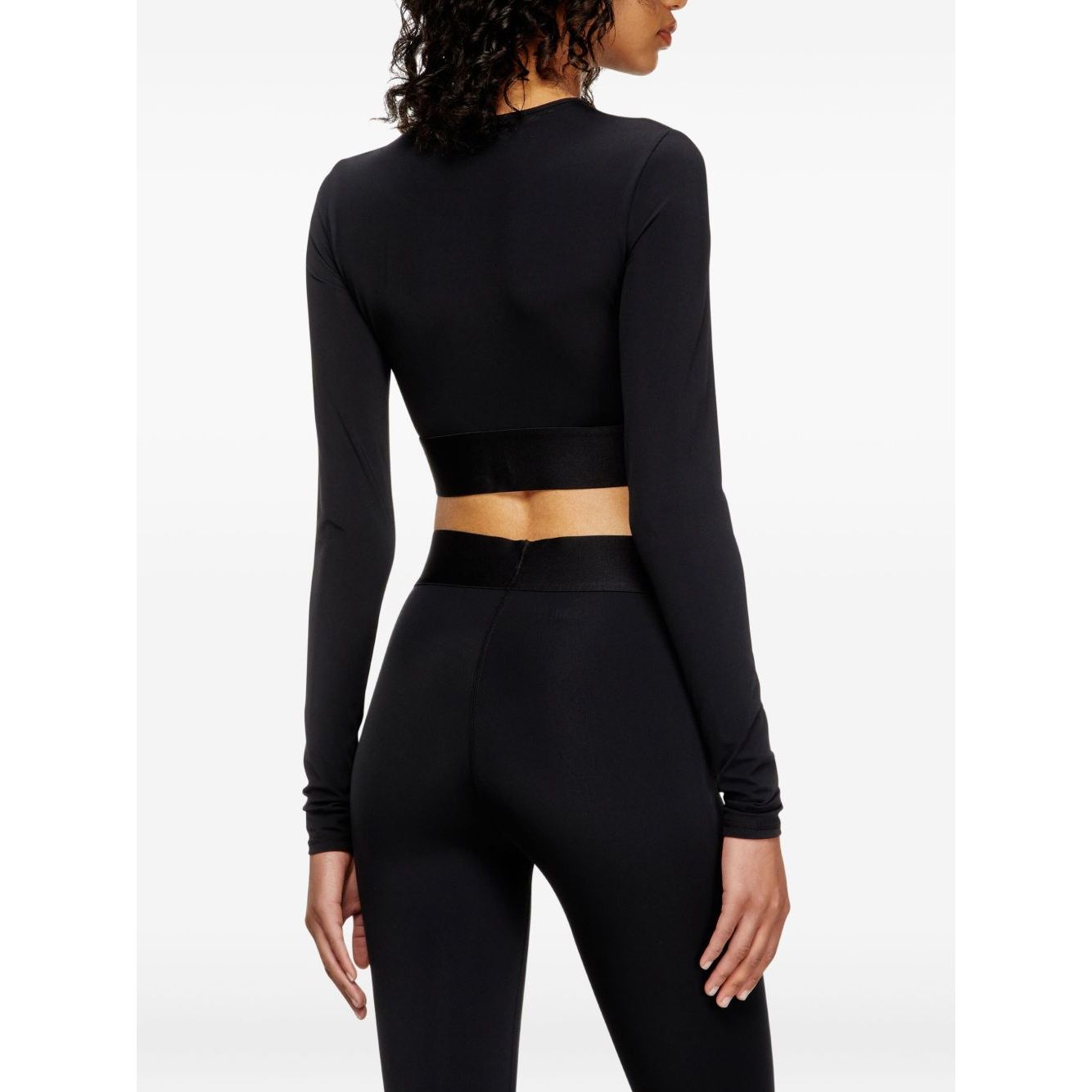 Woman wearing Diesel Sweaters Black long sleeves round neck cropped top, black color, side view. Fashion clothing.