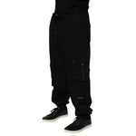 Model wearing Dolce & Gabbana Black Cotton Cargo Jogger Sweatpants Pants with multiple pockets, elastic waistband, and ribbed cuffs.