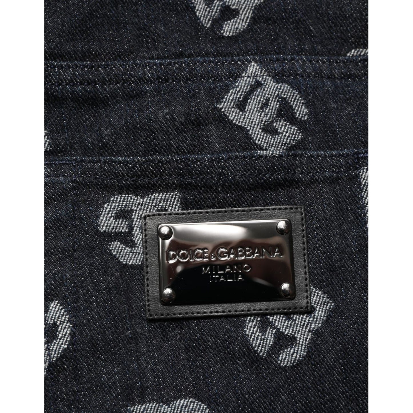 Dolce & Gabbana Black DG Monogram Cotton Skinny Denim Jeans with metal logo plate on dark denim fabric background.