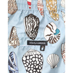 Dolce & Gabbana Blue Seashell Print Nylon Men Shorts Swimwear detail shot with vibrant seashell pattern and brand label.