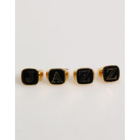 Dolce & Gabbana Gold Tone Brass JAZZ Letter Set 4 Pieces Adjustable Ring, featuring bold black letters on elegant gold-tone rings.
