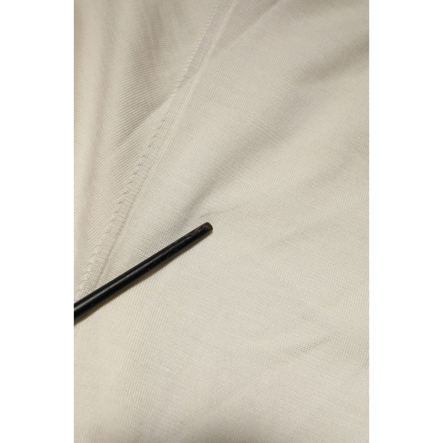 Close-up view of Dolce & Gabbana ivory virgin wool men V-neck knit sweater fabric detail, highlighting texture and quality.