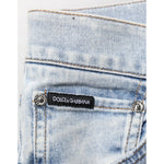Close-up of Dolce & Gabbana Light Blue Distressed Slim Fit Ripped Denim Jeans back pocket with brand label.