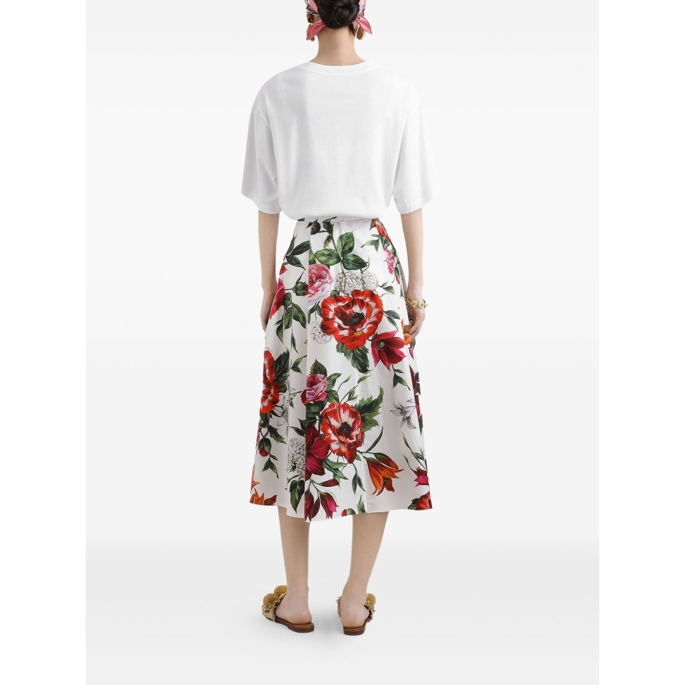 Rear view of a person wearing a white short-sleeve Dolce & Gabbana Logo cotton t-shirt and a floral print skirt, standing on a white background.