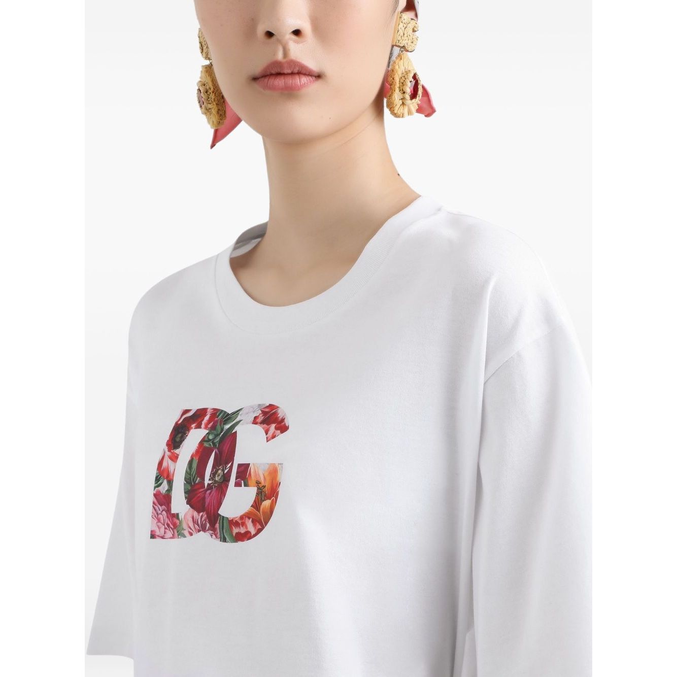 Woman wearing white Dolce & Gabbana Logo cotton t-shirt with floral design, crew neck, short sleeves, and straight hem.