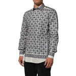 Man wearing a patterned long sleeve dress shirt with a classic button-down design, featuring intricate blue and white geometric patterns.