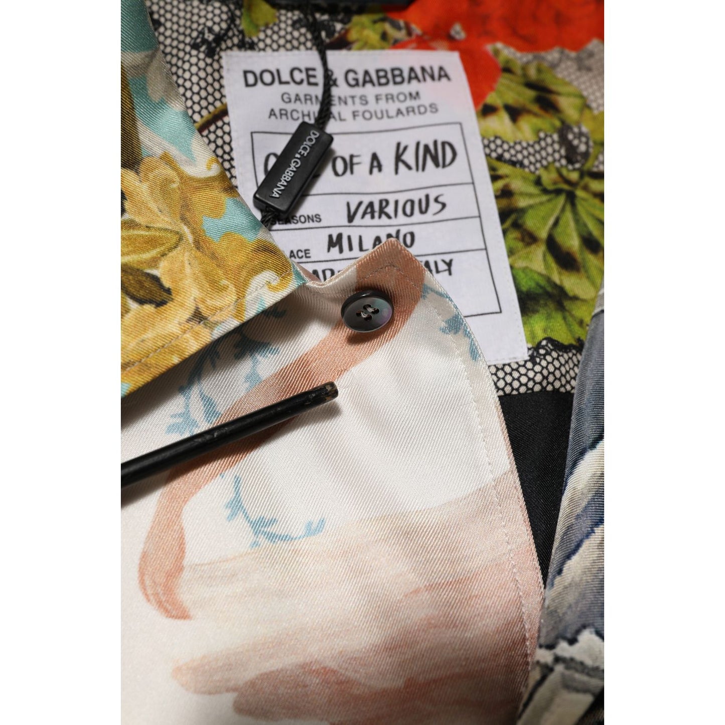 Close-up of Dolce & Gabbana Multicolor Silk Opera Print Men Casual Shirt fabric detail and label.
