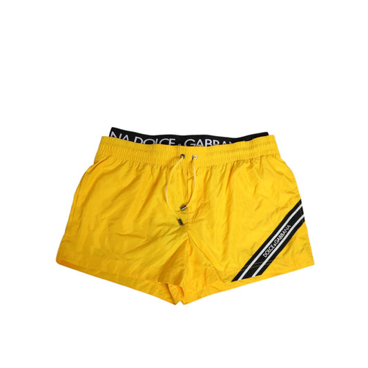 Dolce & Gabbana Yellow Drawstring Beachwear Men Shorts Swimwear with logo detail, elastic waistband, side pockets, and sport finish.