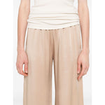 Model wearing beige Fabiana Filippi Trousers Powder, featuring an elasticated waist, side pockets, and a straight hem, wide-leg design.