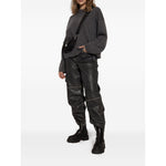 Woman wearing GANNI Boots Black with chunky rubber sole and elasticated side panels, styled with black pants and grey sweater.