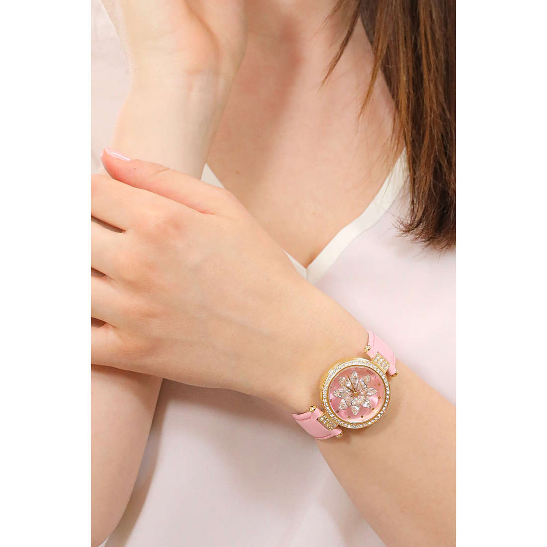 Alt Tag: Lady wearing a pink GUESS watch, showcasing quartz analog movement, on wrist. Stylish accessory for women.