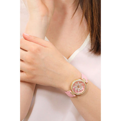 Alt Tag: Lady wearing a pink GUESS watch, showcasing quartz analog movement, on wrist. Stylish accessory for women.