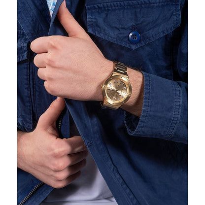 Man wearing a gold watch with a blue jacket, showcasing fashion style and accessory close-up.