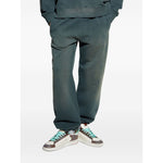 Person wearing Golden Goose Trousers Black with blue elasticated waistband and sneakers, showcasing embroidered logo and cotton fabric.