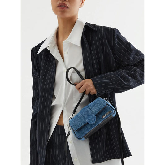 Model holding Jacquemus Denim Le Bambimou Petit Handbag with silver hardware and removable shoulder strap.