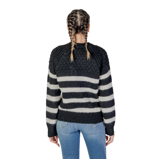 Back view of a woman wearing an Only Black And White Recycled Polyester Sweater, showcasing stripes and texture, perfect for Fall/Winter.