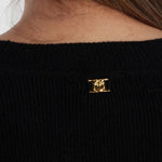 Close-up of metal logo detail on back of PINKO Black Wool Sweater showing crew neck style.