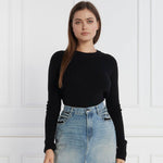 Woman wearing PINKO Black Wool Sweater with crew neck and metal logo detail, paired with denim jeans in a stylish indoor setting.