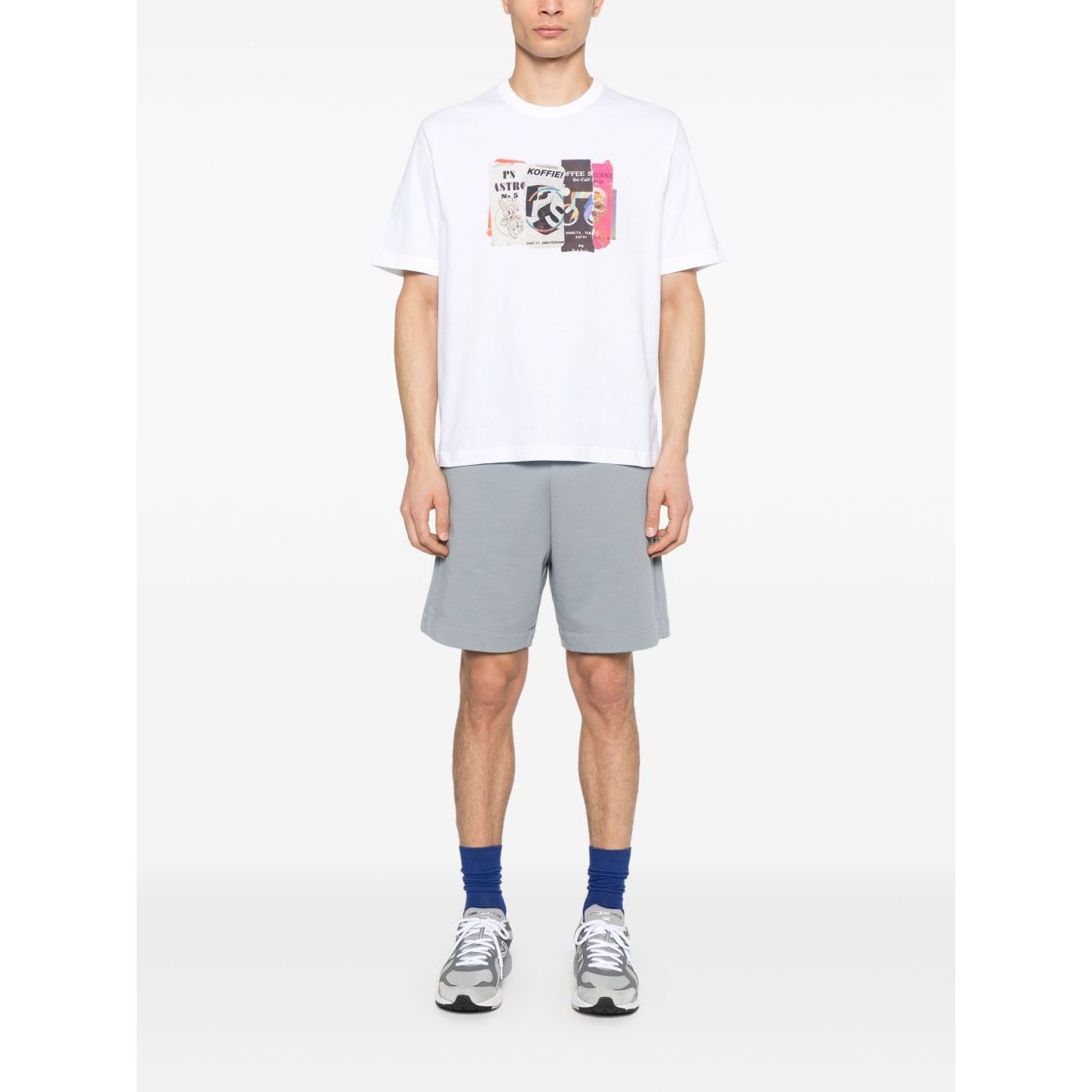 Model wearing Paul Smith T-shirts and Polos White, crew neck short sleeves with graphic print, styled with gray shorts and sneakers.
