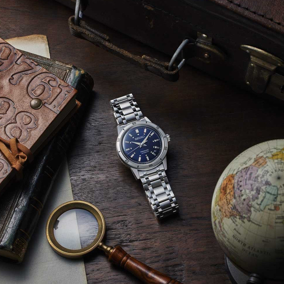 SEIKO PRESAGE MOD. STYLE '60 Automatic watch displayed with vintage accessories on a wooden surface.