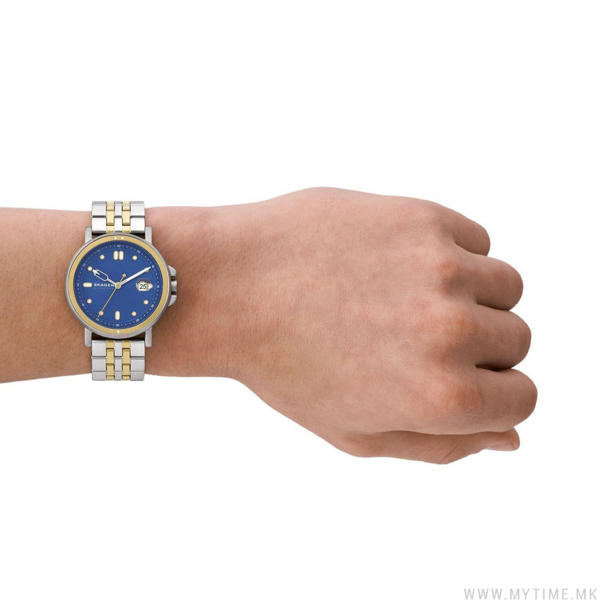 Person wearing SKAGEN DENMARK Mod. SIGNATUR SPORT wristwatch with blue dial and stainless steel strap, on a wrist showing elegance and style.