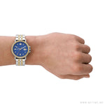Person wearing SKAGEN DENMARK Mod. SIGNATUR SPORT wristwatch with blue dial and stainless steel strap, on a wrist showing elegance and style.