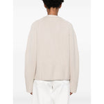 Back view of a SOFT GOAT Sweaters Ivory cashmere cardigan with ribbed trim and plunging V-neck, showcasing its light beige color and design details.