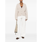 Model wearing SOFT GOAT Sweaters Ivory cashmere cardigan with ribbed trim and v-neck.