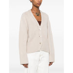 Model wearing SOFT GOAT Sweaters Ivory cashmere cardigan with V-neck, button fastening, and ribbed trim.