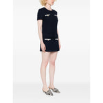 Woman wearing a navy blue Self-portrait Dresses Blue boucle mini dress with belt and pockets, standing against a white background.