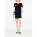 Model wearing Self-portrait Dresses Blue navy boucle mini dress with belt, welt pockets, and concealed zip, holding a white clutch.