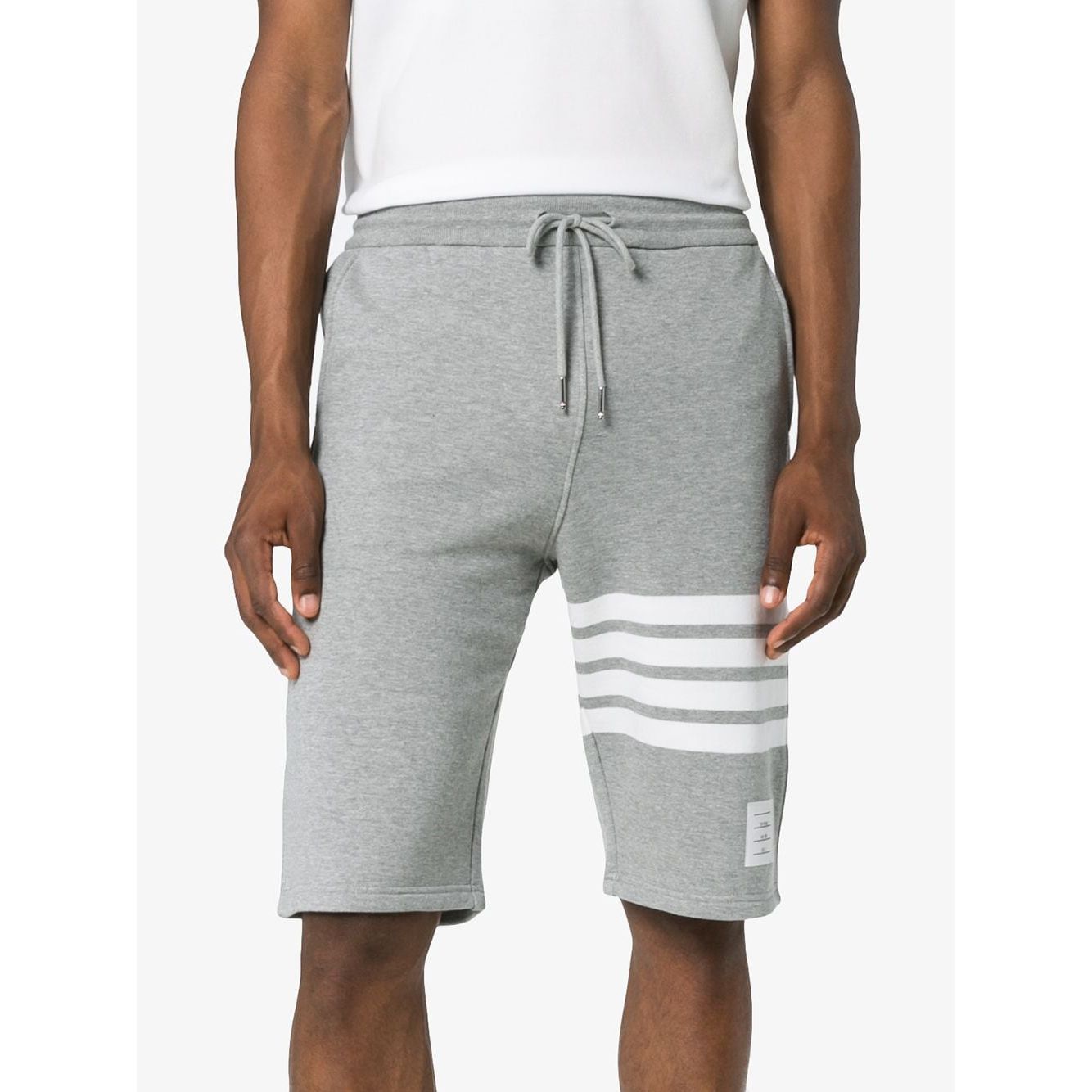 Model wearing Thom Browne Shorts Light Grey with 4-Bar stripe, elastic waistband, and grosgrain ribbon trim, front view.